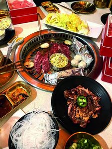 Tisch mit Hotpots und Fleisch, Nudeln, und anderem